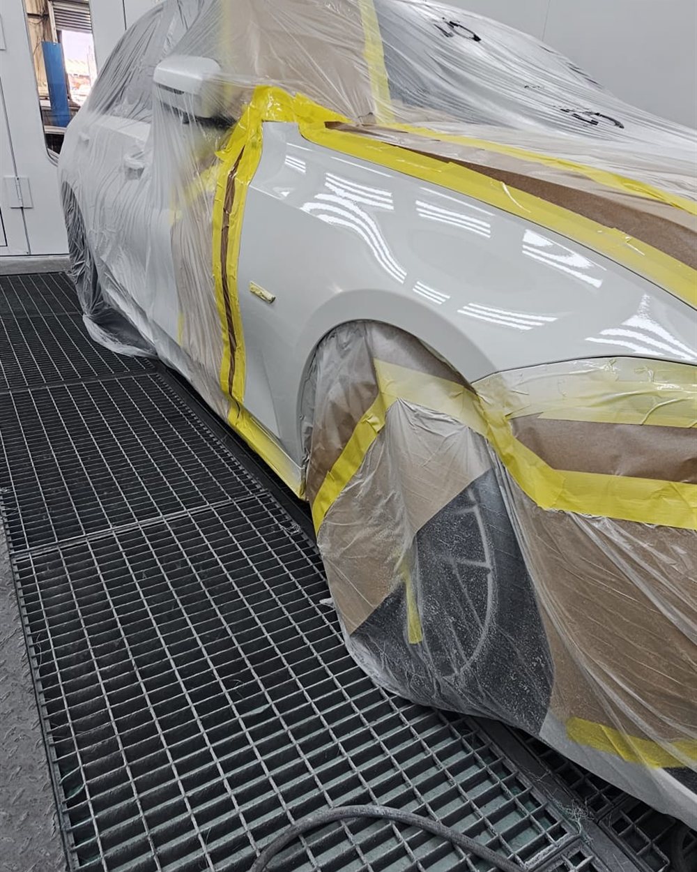 A car fully masked and sheeted before a respray