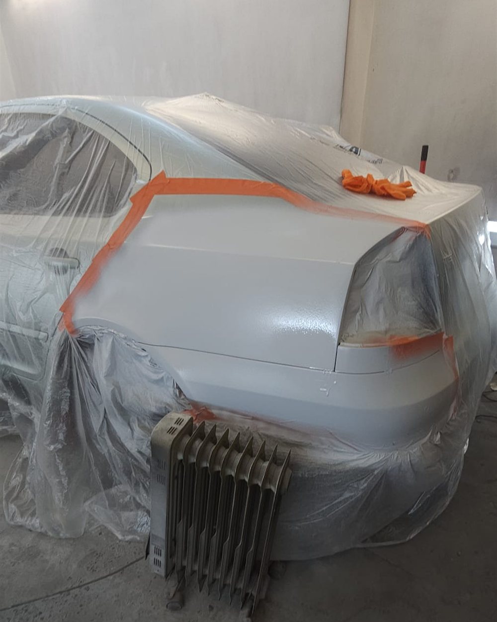 The rear of a car masked off before refinishing
