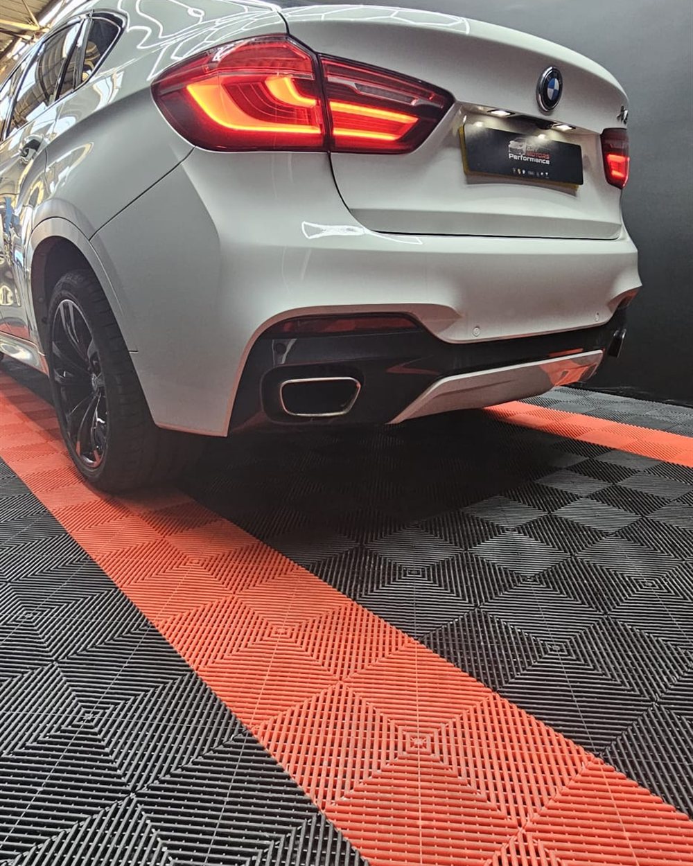 A finished vehicle on the red and black workshop floor