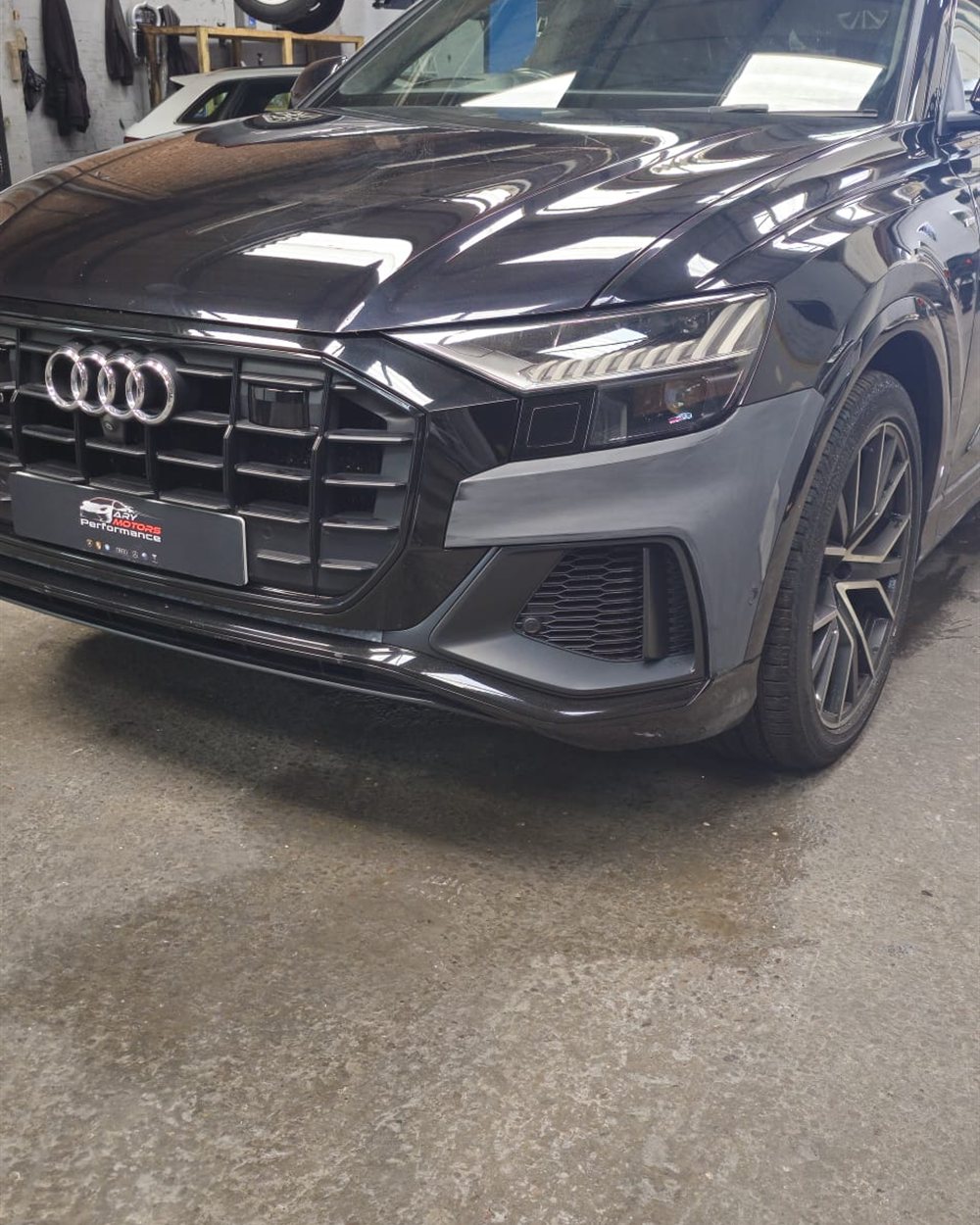 A vehicle up on the ramp inside the workshop