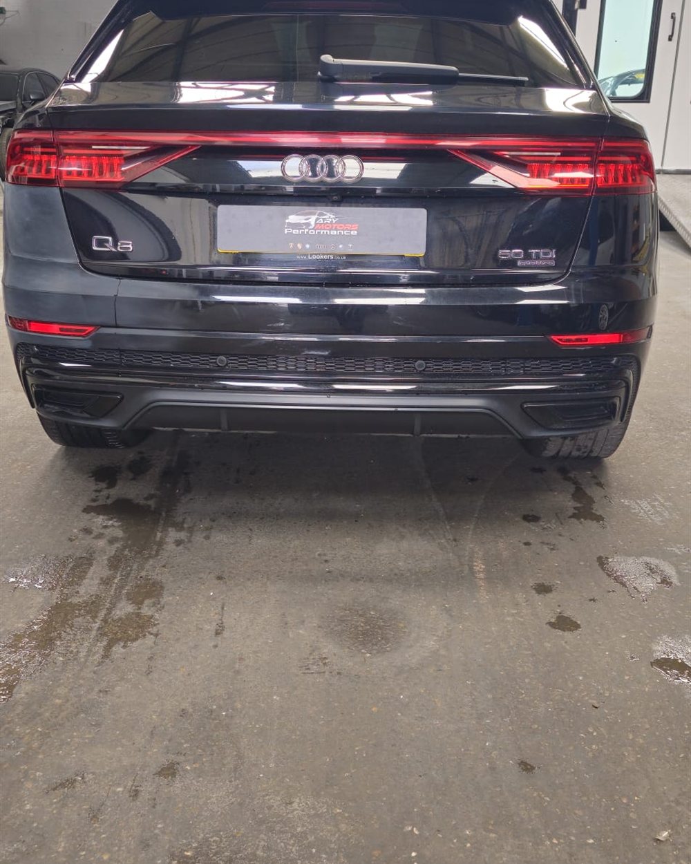 The rear of a car raised on the ramp for inspection